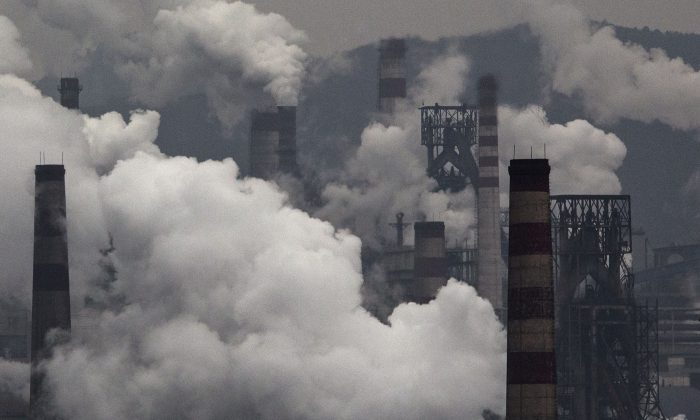 El humo sale de las chimeneas y de un generador de carbón en una fábrica de acero en la provincia industrial de Hebei, China, el 19 de noviembre de 2015. (Kevin Frayer/Getty Images)