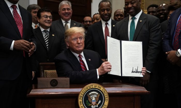 El presidente Donald Trump participa en la firma de una orden ejecutiva para establecer el Consejo de Revitalización y Oportunidades de la Casa Blanca mientras el secretario de Vivienda y Desarrollo Urbano, el secretario Ben Carson y el senador Tim Scott (R-S.C.) observan en la Sala Roosevelt de la Casa Blanca en Washington, el 12 de diciembre de 2018. (Alex Wong/Getty Images)