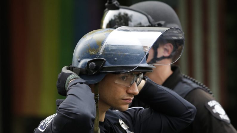 Un policía ajusta su casco en una barricada fuera de la Comisaría Este del Departamento de Policía de Seattle en Seattle, Washington, el 2 de junio de 2020. (Jason Redmond/AFP/Getty Images)

