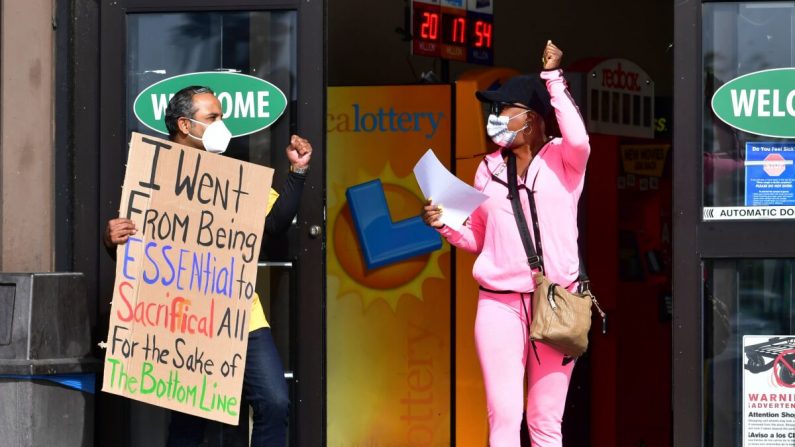 Una mujer hace un gesto de apoyo a los trabajadores del supermercado que sostienen pancartas en protesta frente a un supermercado Food 4 Less en Long Beach, California, el 3 de febrero de 2021. (Frederic J. Brown/AFP vía Getty Images)
