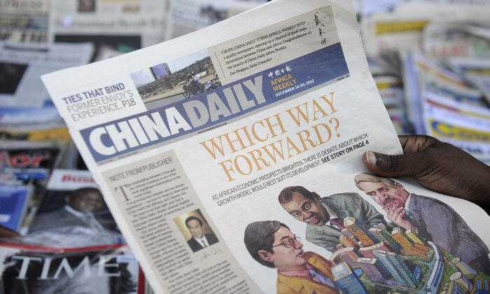 Un cliente lee un ejemplar de un periódico chino de la edición de África frente a un quiosco de prensa en la capital de Kenia el 14 de diciembre de 2012. (Tony Karumba/AFP vía Getty Images)