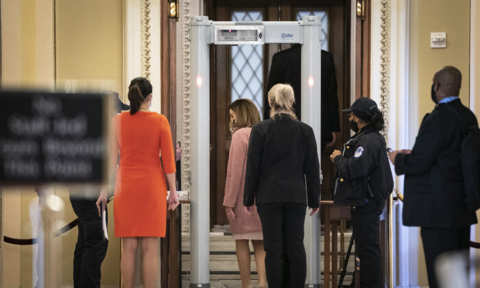 La presidenta de la Cámara de Representantes, Nancy Pelosi (D-Calif.), pasa por un detector de metales antes de ingresar a la Sala de la Cámara en el Capitolio de EE. UU., en Washington, el 21 de enero de 2021. (Drew Angerer/Getty Images)