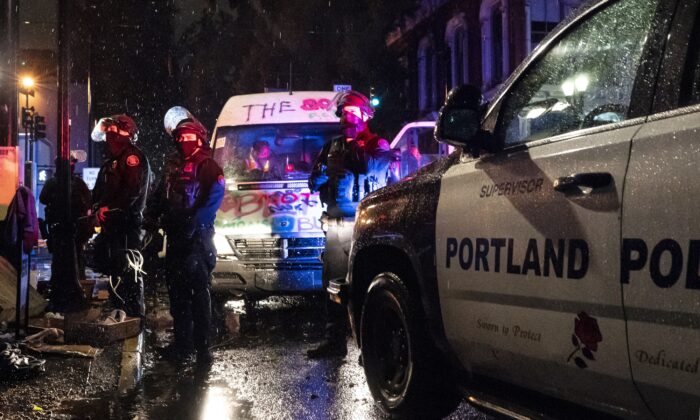 La policía estadounidense detiene a los pasajeros de una furgoneta vinculada a unos disturbios en Portland, Oregón, el 11 de octubre de 2020. (Nathan Howard/Getty Images)