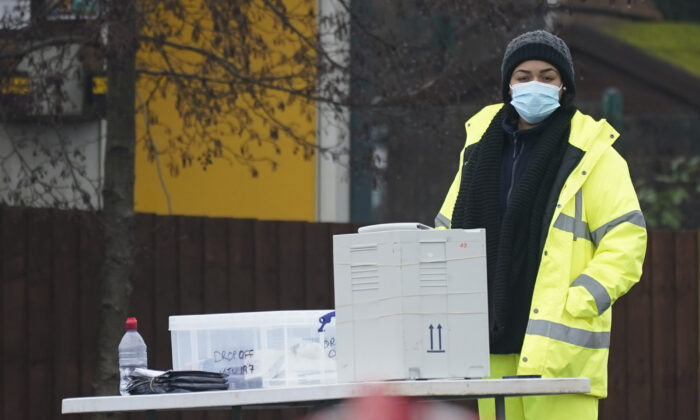 Una persona lleva los test de COVID-19 a una estación donde se conducen las pruebas de laboratorio en un esfuerzo por rastrear una variante sudafricana del virus del PCCh, encontrada en la zona en Walsall, Reino Unido, el 2 de febrero de 2021. (Christopher Furlong/Getty Images)