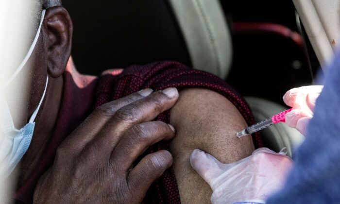 Un hombre recibe la primera dosis de la vacuna contra el virus del PCCh administrada durante las vacunaciones masivas en el estadio de béisbol Coors Field en Denver, Colorado, el 30 de enero de 2021. (Chet Strange/AFP vía Getty Images)