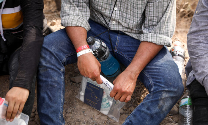 Un inmigrante ilegal con dos pulseras que los cárteles mexicanos han estado utilizando para controlar el contrabando de personas hacia Estados Unidos, cerca de Peñitas, Texas, el 15 de marzo. 2021. (Charlotte Cuthbertson/The Epoch Times)