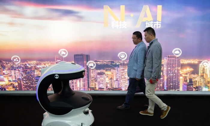 Visitantes pasan junto a un robot de seguridad que funciona con IA (inteligencia artificial) en la 14a Exposición Internacional de Seguridad Pública de China, en el Centro Internacional de Exposiciones de China, en Beijing, el 24 de octubre de 2018. (Nicolas Asfouri/AFP vía Getty Images)