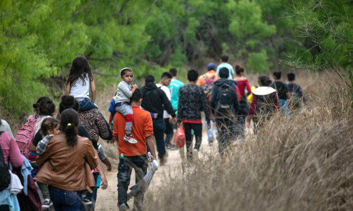 Varias decenas de inmigrantes ilegales, la mayoría de ellos de Honduras, caminan hacia un puesto de control de la Patrulla Fronteriza de EE. UU. después de cruzar el Río Grande desde México cerca de Mission, Texas, el 23 de marzo de 2021. (John Moore/Getty Images)