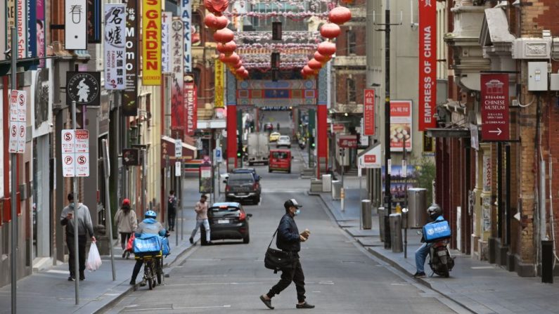 Un hombre con una máscara facial cruza una calle tranquila en el área de Chinatown de Melbourne, Australia, el 13 de agosto de 2020. (William West / AFP a través de Getty Images)