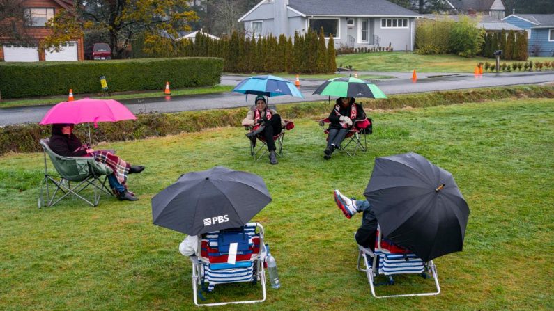 Una familia se sienta a charlar en el Parque Estatal Histórico Peace Arch el 1 de enero de 2021 en Blaine, Washington. (David Ryder / Getty Images)