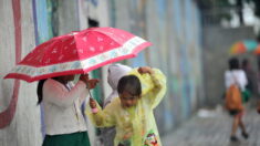 Adolescente chilena sin internet hace su tarea bajo la lluvia mientras mamá la cubre con un paraguas