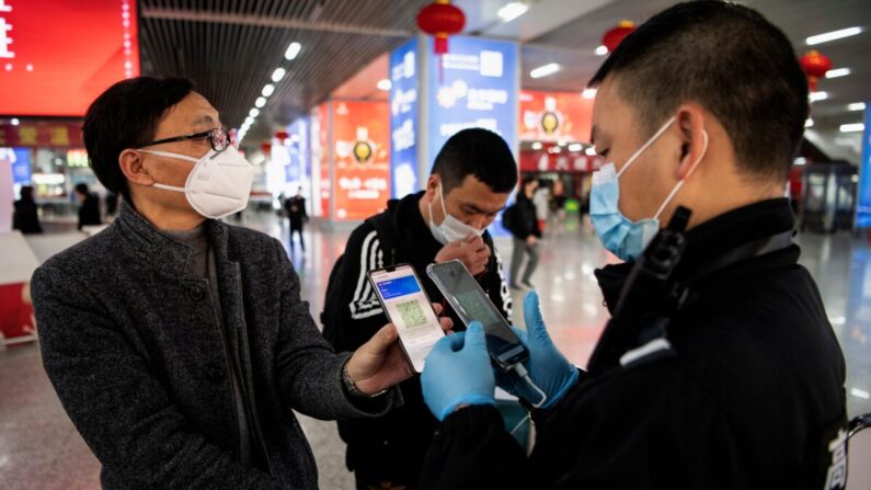 Un pasajero muestra un código QR verde en su teléfono para mostrar su estado de salud a la seguridad al llegar a la estación de tren de Wenzhou, en Wenzhou, China, el 28 de febrero de 2020. (Noel Celis/AFP vía Getty Images)
