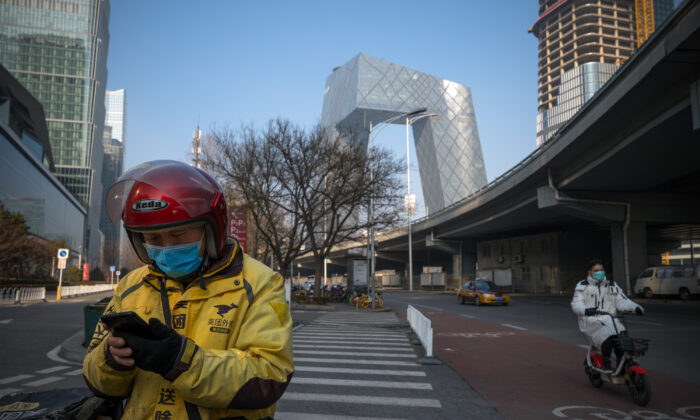 Un repartidor utiliza su teléfono en las calles del Distrito Central de Negocios en Beijing, China, el 10 de febrero de 2020. (Andrea Verdelli/Getty Images)