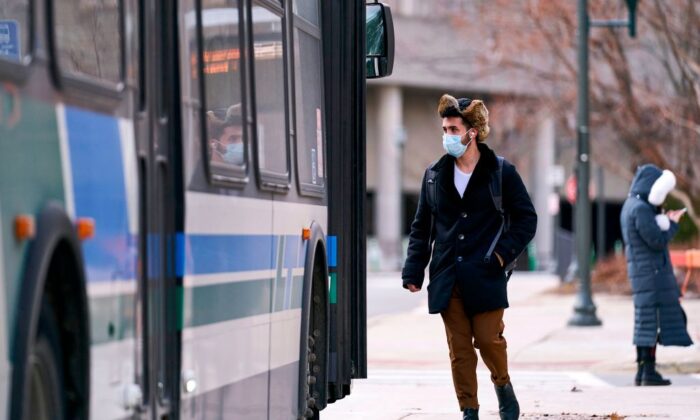 Un hombre con una máscara sube a un autobús en el campus de la Western University en London, Ontario, Canadá, el 13 de marzo de 2020. (Geoff Robins/AFP a través de Getty Images)