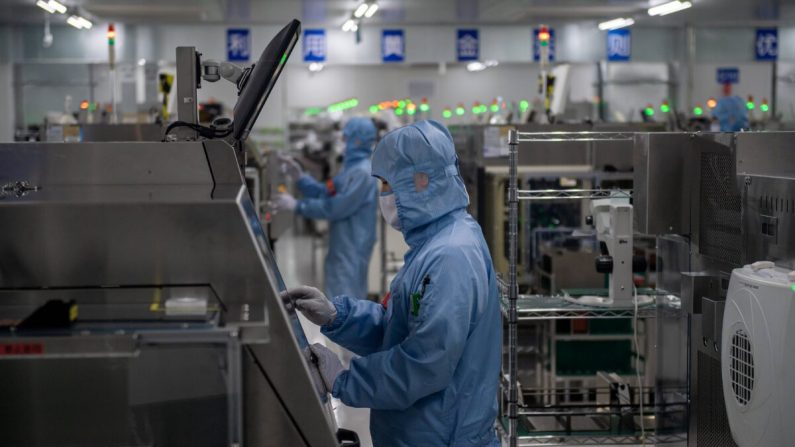 Los trabajadores son vistos dentro de la cadena de producción en una fábrica de semiconductores en Beijing, China, el 14 de mayo de 2020. (Nicolas Asfouri/AFP vía Getty Images)
