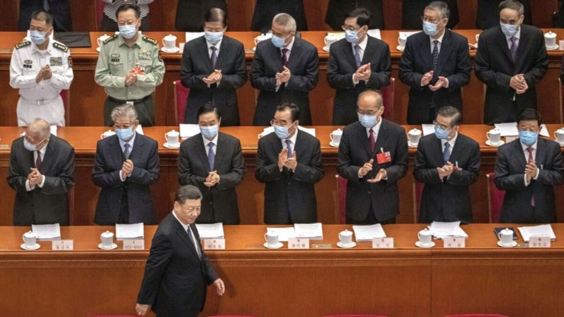 El presidente chino Xi Jinping es aplaudido por los delegados que llevan mascarillas protectoras mientras llega a la apertura de la Asamblea Popular Nacional en el Gran Salón del Pueblo en Beijing, China, el 22 de mayo de 2020. (Kevin Frayer/Getty Images)
