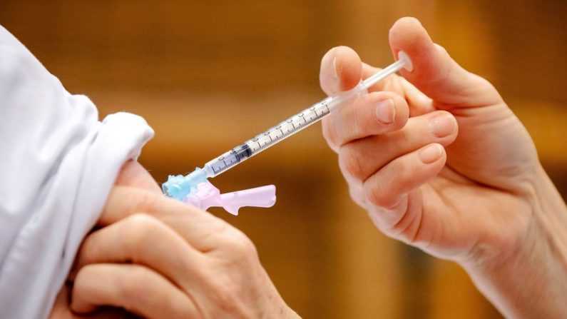 Un trabajador de la salud administra una dosis de vacuna contra la covid-19 a un empleado de cuidados intensivos del hospital Gelderse Vallei en Ede (Países Bajos) el 7 de enero de 2021. (Robin Van Lonkhuijsen / ANP / AFP vía Getty Images)