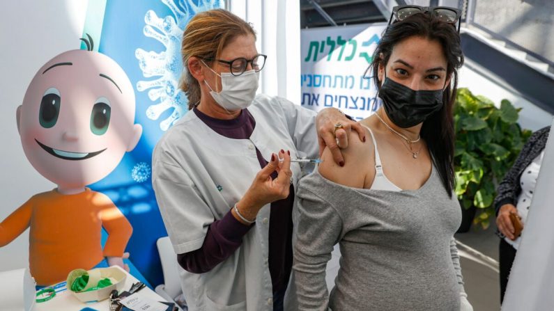 Una sanitaria administra una dosis de la vacuna contra la COVID-19 de Pfizer-BioNtech a una mujer embarazada en los Servicios de Salud Clalit en Tel Aviv (Israel) el 23 de enero de 2021. (Jack Guez/AFP vía Getty Images)