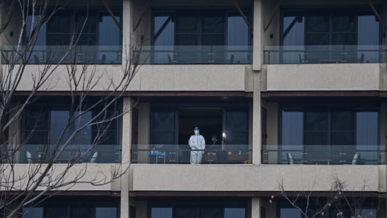 Un trabajador de la salud espera a los miembros del equipo de la Organización Mundial de la Salud (OMS) que investiga los orígenes del COVID-19 en un balcón del hotel Wuhan Hilton Optics Valley en Wuhan, provincia central china de Hubei, el 6 de febrero de 2021. (Hector Retamal/AFP vía Getty Images)
