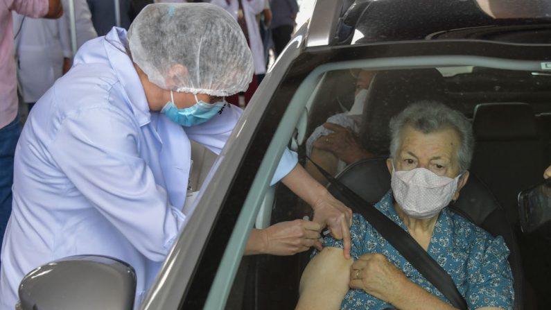 Una anciana brasileña recibe una dosis de la vacuna Coronavac contra la covid-19 en un paseo por el centro de vacunación en el Estadio Pacaembu en Sao Paulo, Brasil, el 8 de febrero de 2021. (Nelson Almeida / AFP vía Getty Images)