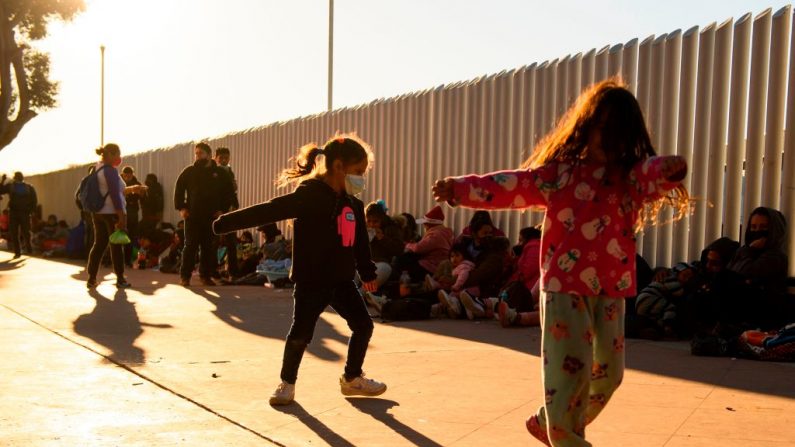 Los niños juegan mientras las familias de los solicitantes de asilo esperan fuera del puerto fronterizo de El Chaparral para cruzar a Estados Unidos, en Tijuana, estado de Baja California, México, el 19 de febrero de 2021. (Patrick T.Fallon/AFP a través de Getty Images)