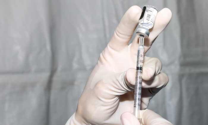 Un técnico de farmacia prepara una dosis de la vacuna COVID-19 de Pfizer-BioNTech durante un evento de vacunación masiva en el estacionamiento de Coors Field en Denver, Colorado, el 20 de febrero de 2021. (Michael Ciaglo/Getty Images)