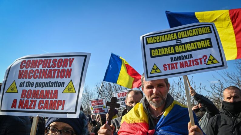 Los manifestantes contra la vacunación sostienen un cartel que dice en rumano e inglés "Vacunación obligatoria = gaseamiento obligatorio, el 7 de marzo de 2021. (Daniel MIHAILESCU/AFP a través de Getty Images)