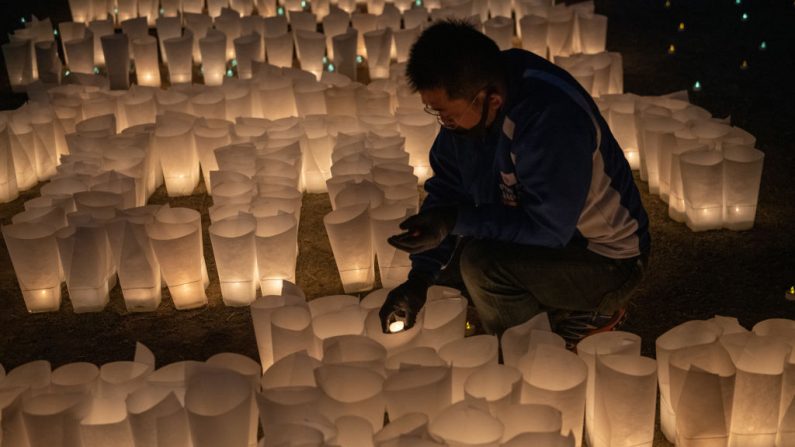 Un hombre enciende velas durante una ceremonia de linterna para conmemorar el décimo aniversario del terremoto y tsunami de Tohoku de 2011 el 11 de marzo de 2021 en Ishinomaki, Japón. (Carl Court / Getty Images)