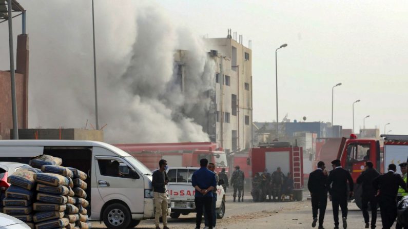 Bomberos y fuerzas de seguridad se reúnen alrededor de una fábrica de ropa en llamas en las afueras del este de la capital egipcia, El Cairo, el 11 de marzo de 2021. Al menos 20 personas murieron y más de 24 resultaron heridas en el incendio, dijeron fuentes médicas y de seguridad. (Khaled Kamel / AFP a través de Getty Images)
