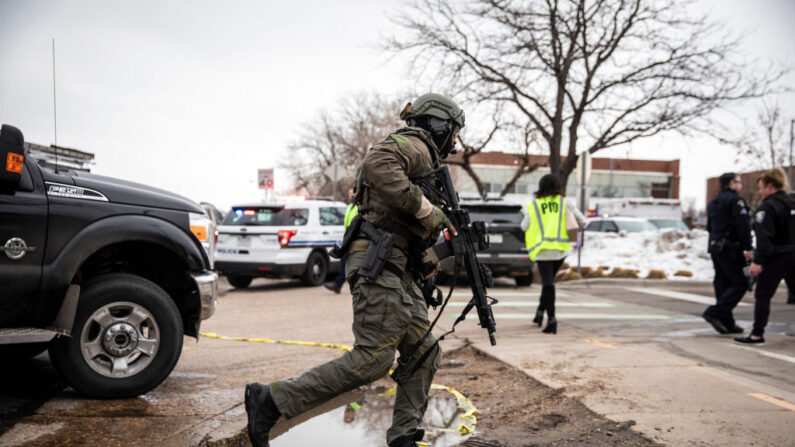 Un miembro del equipo SWAT corre hacia una tienda de comestibles, King Soopers, donde un hombre armado abrió fuego el 22 de marzo de 2021, en Boulder, Colorado. (Chet Strange/Getty Images)
