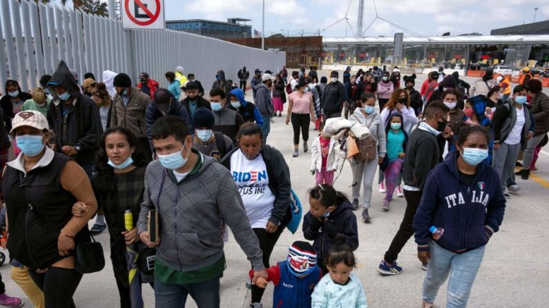 Migrantes y solicitantes de asilo se mueven después de una manifestación en el puerto de cruce de San Ysidro pidiendo a las autoridades estadounidenses que les permitan iniciar su proceso migratorio en Tijuana, estado de Baja California, México, el 23 de marzo de 2021. (Guillermo Arias / AFP vía Getty Images)