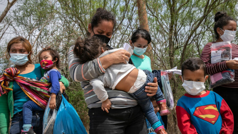 Solicitantes de asilo esperan ser transportados por agentes de la Patrulla Fronteriza de Estados Unidos después de que un grupo de inmigrantes cruzara el Río Grande hacia Texas el 25 de marzo de 2021 en Hidalgo, Texas. (John Moore/Getty Images)
