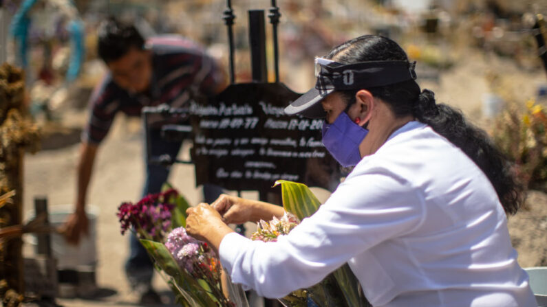Una persona colocó flores en la tumba de un familiar fallecido en el cementerio de San Miguel Xico el 25 de marzo de 2021 en el Valle de Chalco, México. (Hector Vivas / Getty Images)