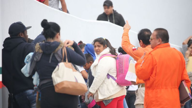 Una madre migrante (Centro) escucha a los funcionarios mexicanos con sus dos hijas (NO APARECEN EN LA FOTO) en su camino hacia el puerto de entrada para pedir asilo en EE. UU., el 21 de junio de 2018 en Tijuana, México. (Foto de Mario Tama/Getty Images)