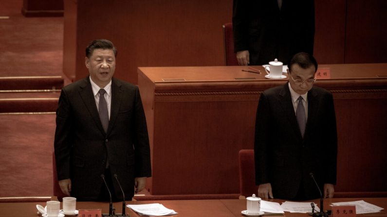 El líder chino Xi Jinping (izq.) y el primer ministro Li Keqiang cantan el himno nacional en una ceremonia que conmemora el 70º aniversario de del ingreso de China en la Guerra de Corea, en el Gran Salón del Pueblo en Beijing, China, el 23 de octubre de 2020. (Kevin Frayer/Getty Images)

