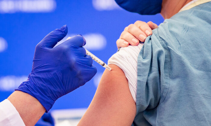 Un profesional sanitario del Hospital St. Joseph recibe una de las primeras inyecciones de la vacuna anti-COVID en Orange, California, el 16 de diciembre de 2020. (John Fredricks/The Epoch Times)