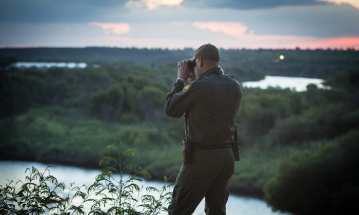 Un agente de la Patrulla Fronteriza observa a las personas que cruzan ilegalmente el Río Bravo desde México hacia la ciudad de Roma en Texas, el 31 de mayo de 2017. (Benjamin Chasteen/The Epoch Times)
