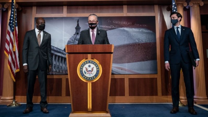 Flanqueado por (I-D) el senador Raphael Warnock (D-GA) y el senador Jon Ossoff (D-GA), el líder de la mayoría del Senado Chuck Schumer (D-NY) habla durante una conferencia de prensa en el Capitolio de los Estados Unidos el 11 de febrero de 2021 en Washington, DC. (Drew Angerer/Getty Images)