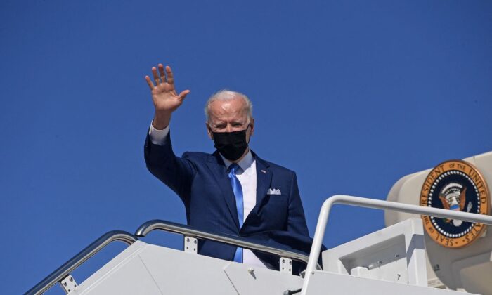 El presidente Joe Biden saluda mientras sube al Air Force One en la Base Conjunta Andrews, Maryland, el 26 de marzo de 2021. (Olivier Douliery/AFP vía Getty Images)