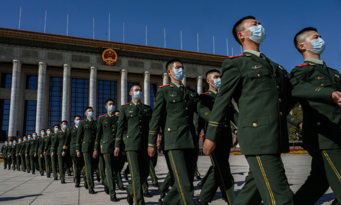 Soldados chinos del Ejército Popular de Liberación marchan tras una ceremonia que marca el 70º aniversario de la entrada de China en la Guerra de Corea, en el Gran Salón del Pueblo en Beijing (China), el 23 de octubre de 2020. (Kevin Frayer/Getty Images)