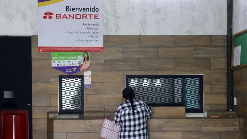 Fotografía que muestra a una mujer que retira dinero en una casa de cambio de divisas en el municipio de Tepeojuma (México). EFE/Hilda Ríos/Archivo