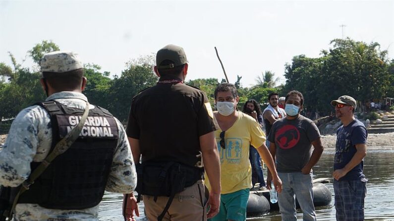 Miembros de la Guardia Nacional y del Instituto Nacional de Migración vigilan el paso de personas el 23 de marzo de 2021, en el Río Suchiate, en la ciudad de Tapachula, en el estado de Chiapas (México). EFE/ Juan Manuel Blanco