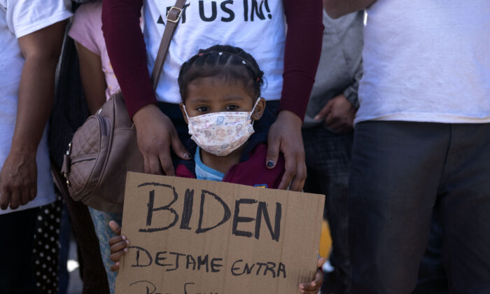 Dareli Matamoros, una niña de Honduras, sostiene un cartel en el que pide al presidente Joe Biden que la deje entrar durante una manifestación de migrantes en el puesto fronterizo de San Ysidro en Tijuana, México, el 2 de marzo de 2021. (Guillermo Arias/AFP vía Getty Images)