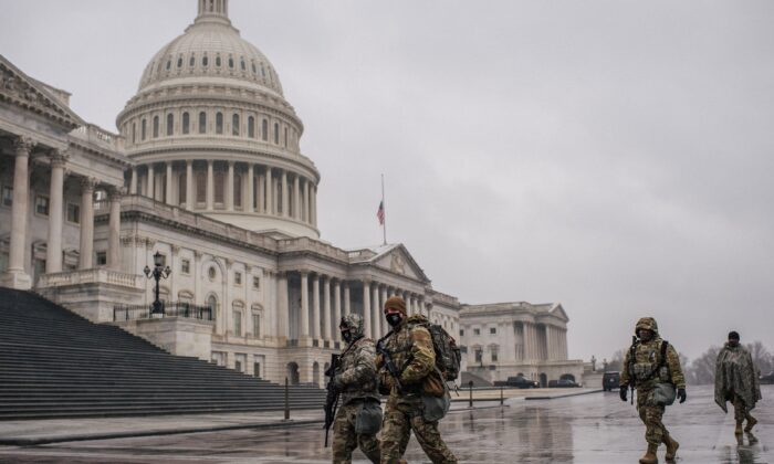 Los miembros de la Guardia Nacional caminan por las instalaciones del Capitolio de EE. UU. en Washington, el 13 de febrero de 2021. (Brandon Bell/Getty Images)