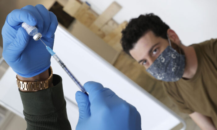 Un trabajador sanitario israelí del Servicio de Salud Maccabi administra una dosis de la vacuna Pfizer-BioNtech a un hombre en Tel Aviv, Israel, el 24 de febrero de 2021. (Jack Guez/AFP vía Getty Images)