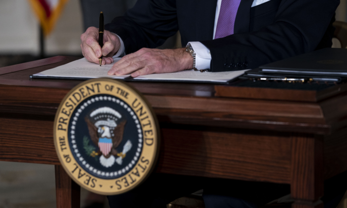 El presidente de EE.UU., Joe Biden, firma órdenes ejecutivas en el Comedor de Estado de la Casa Blanca en Washington el 26 de enero de 2021. (Doug Mills-Pool/Getty Images)