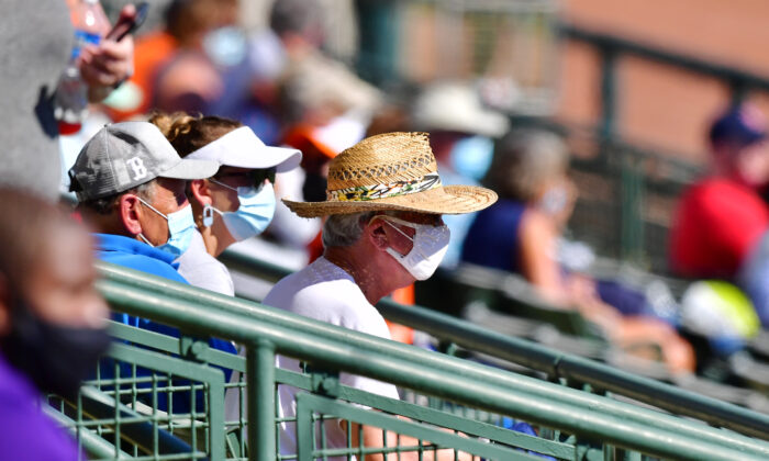 Los espectadores con mascarilla observan un juego de entrenamiento de primavera entre los Orioles de Baltimore y los Medias Rojas de Boston en el Estadio Ed Smith en Sarasota, Florida, el 4 de marzo de 2021. (Julio Aguilar/Getty Images)