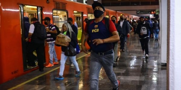Viajeros entran a un tren subterráneo en la estación de metro Tacubaya durante el pico de contagio por el virus del PCCh el 11 de mayo de 2020 en la Ciudad de México. (Manuel Velasquez/Getty Images)