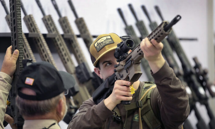 Los invitados miran los visores de un rifle en un stand de la convención de la NRA en Indianápolis, Indiana, el 27 de abril de 2019. (Scott Olson/Getty Images)