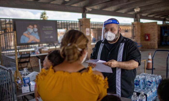 Solicitantes de asilo se registran para pruebas rápidas de COVID-19 en una zona de aislamiento en una estación de autobuses en Brownsville, Texas, el 26 de febrero de 2021. (John Moore/Getty Images)

